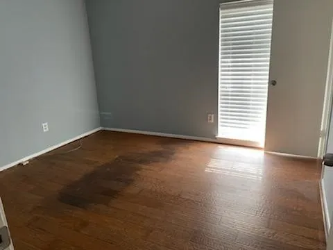 a view of a room with wooden floor and a window