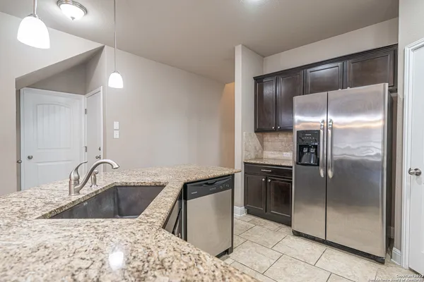 a kitchen with a refrigerator sink and cabinets