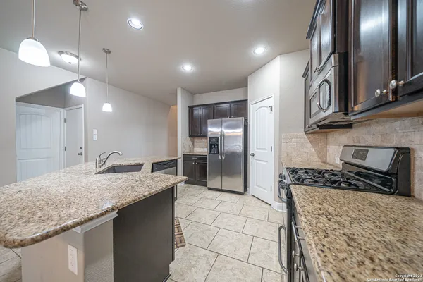 a kitchen with stainless steel appliances granite countertop a sink stove and refrigerator