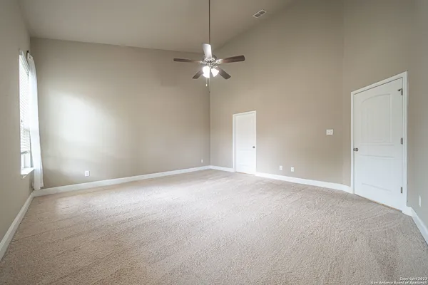 an empty room with windows and fan