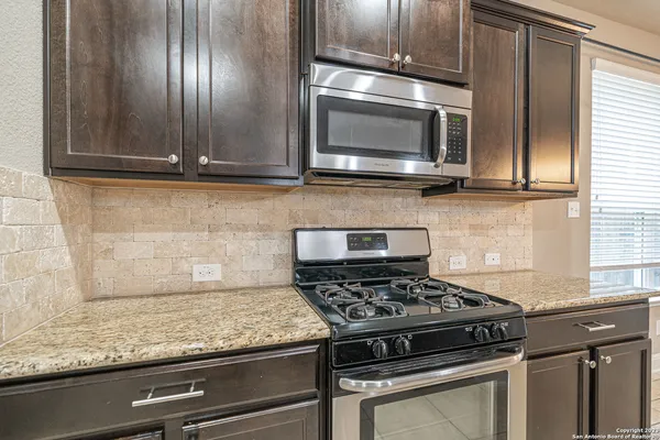 a kitchen with granite countertop stainless steel appliances and cabinets