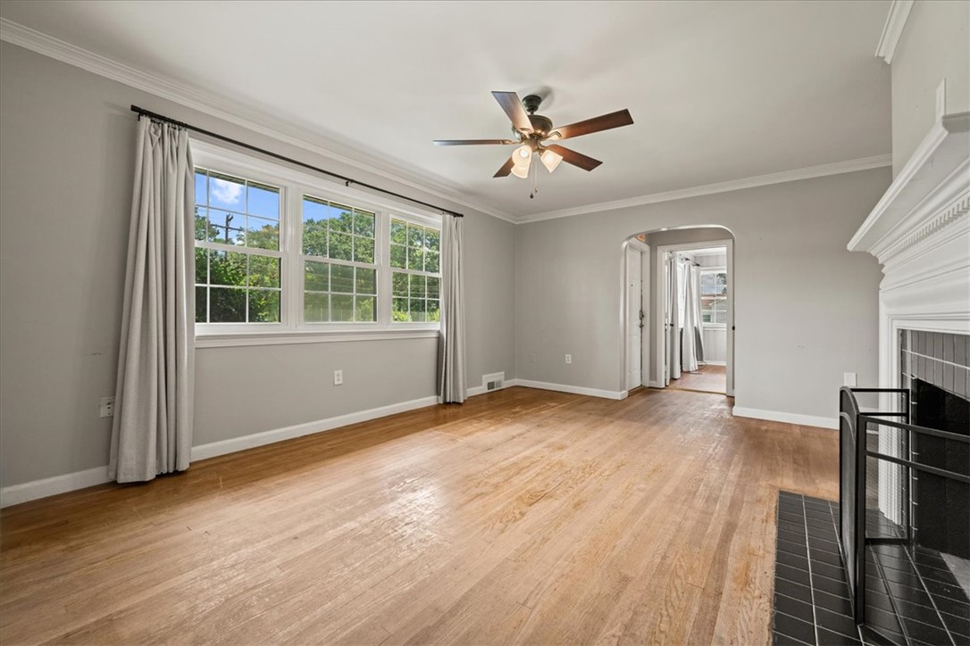 212 East Shockley Ferry Road Anderson, SC 29624 - Photo 6 of 28 Well-lit living room showcasing rich hardwood flooring and a classic fireplace.