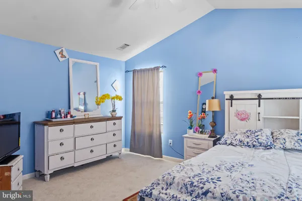 a bedroom with a bed and a dresser in it