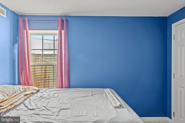 a bed sitting in a bedroom next to a window