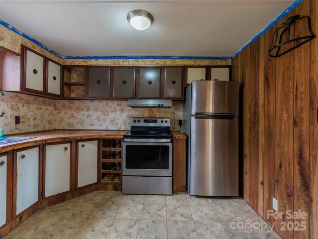 a kitchen with stainless steel appliances a refrigerator and a stove top oven