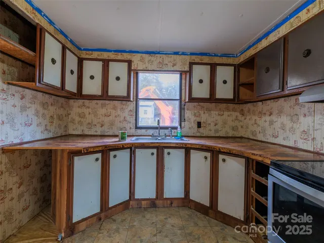 a kitchen with stainless steel appliances granite countertop a sink stove and cabinets