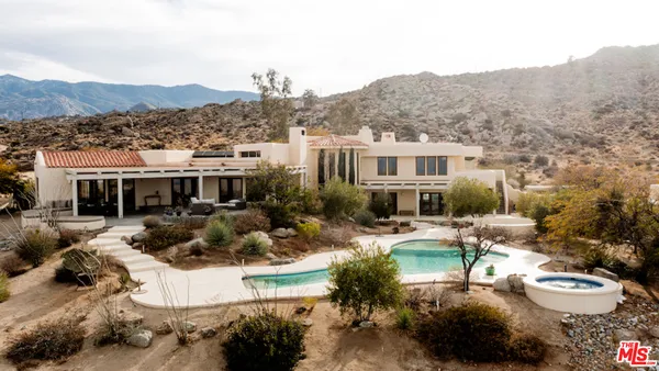 a view of a house with a yard and mountain view in front of it