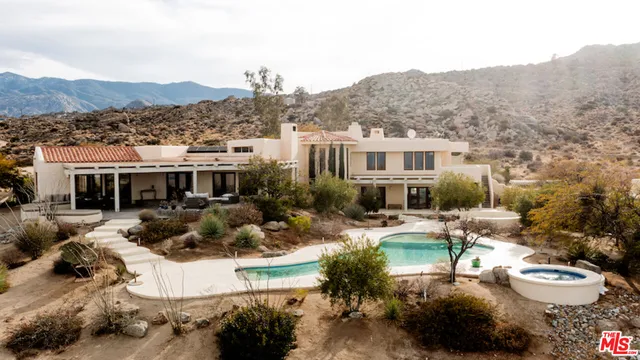 a view of a house with a yard and mountain view in front of it