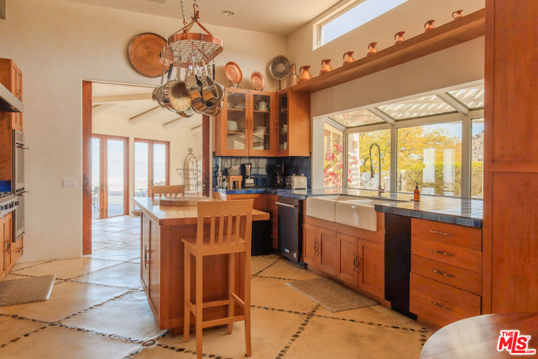 57425 Palm Seco Circle Mountain Center, CA 92561 - Photo 19 of 61 a kitchen with cabinets a island and chairs in it