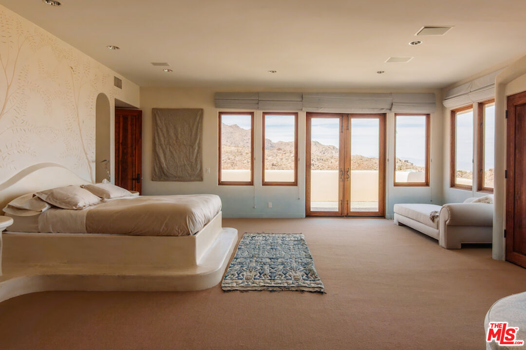 57425 Palm Seco Circle Mountain Center, CA 92561 - Photo 23 of 61 a bedroom with a bed couch and a large window