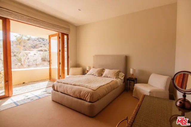 a spacious bedroom with a bed and a large window