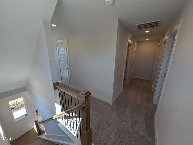 a view of a hallway with wooden floor and stairs