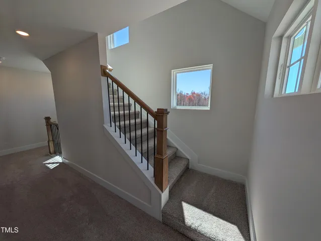 an empty room with windows and fireplace