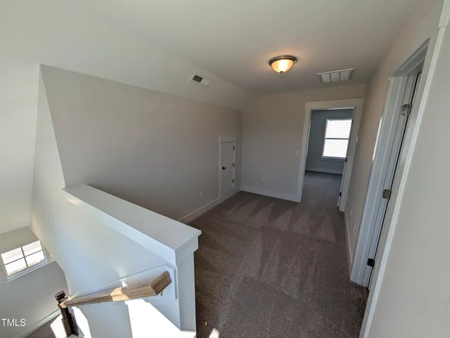 a view of an empty room with a window and closet area