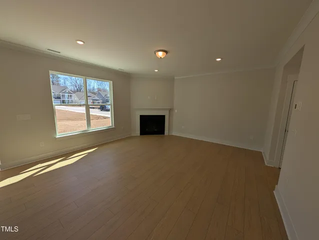 en empty room with windows and fireplace