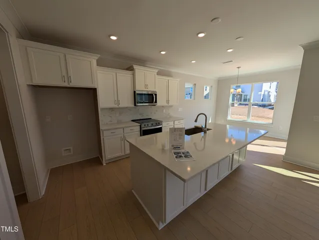 a view of kitchen with cabinets microwave and stove