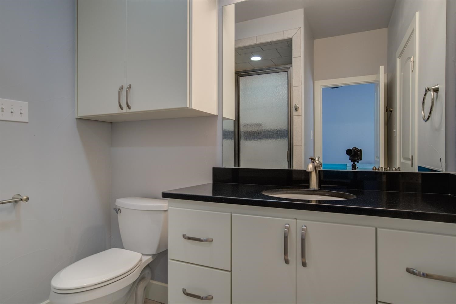 4002 113th Street Lubbock, TX 79423 - Photo 29 of 50 a bathroom with a granite countertop toilet sink and mirror