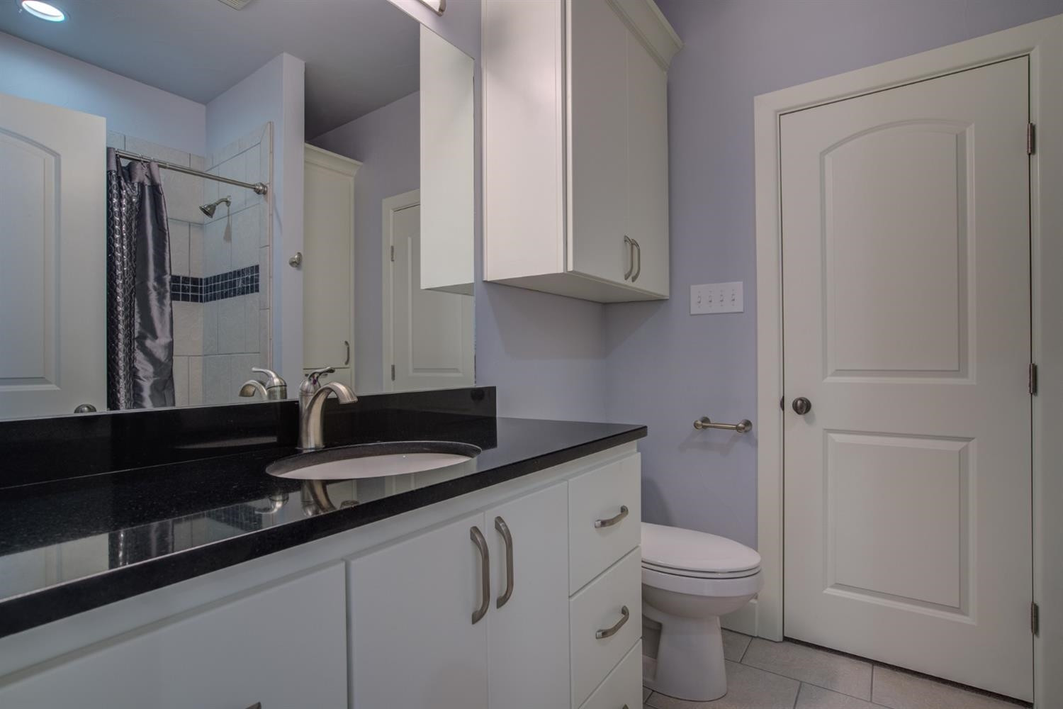 4002 113th Street Lubbock, TX 79423 - Photo 33 of 50 a bathroom with a granite countertop sink a toilet and a mirror