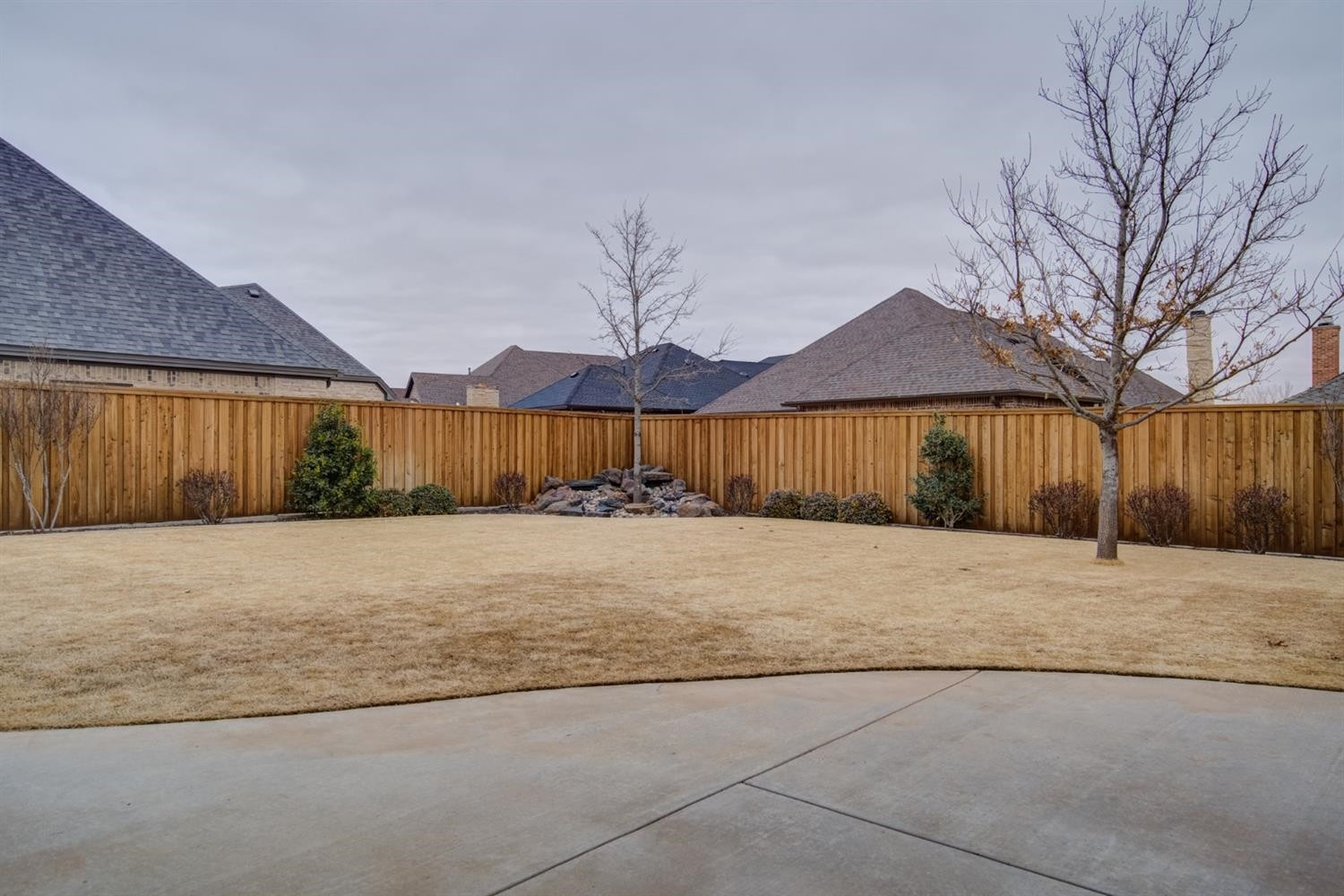 4002 113th Street Lubbock, TX 79423 - Photo 47 of 50 a house with a wooden fence and large trees