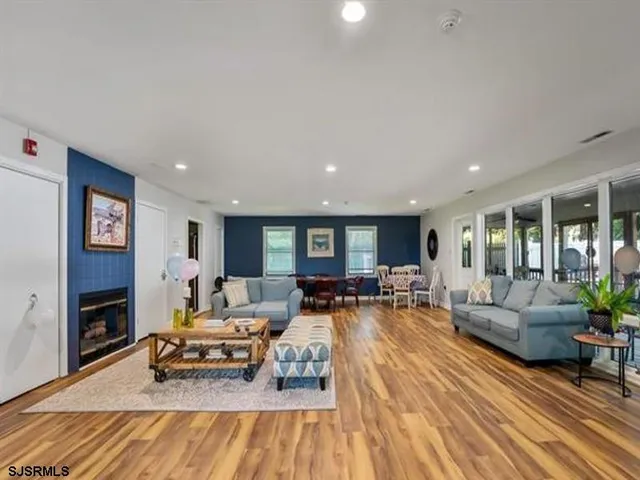 a living room with furniture hard wood floor and a flat screen tv