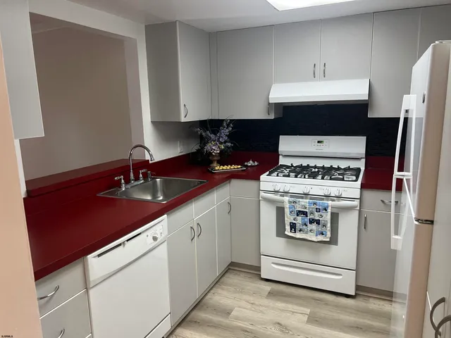 a kitchen with stainless steel appliances a sink stove and cabinets