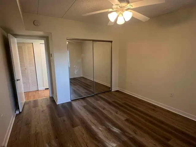 a view of hallway with window and wooden floor