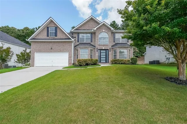a front view of a house with a yard and garage