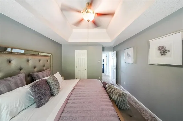 a bedroom with a large bed and a chandelier fan