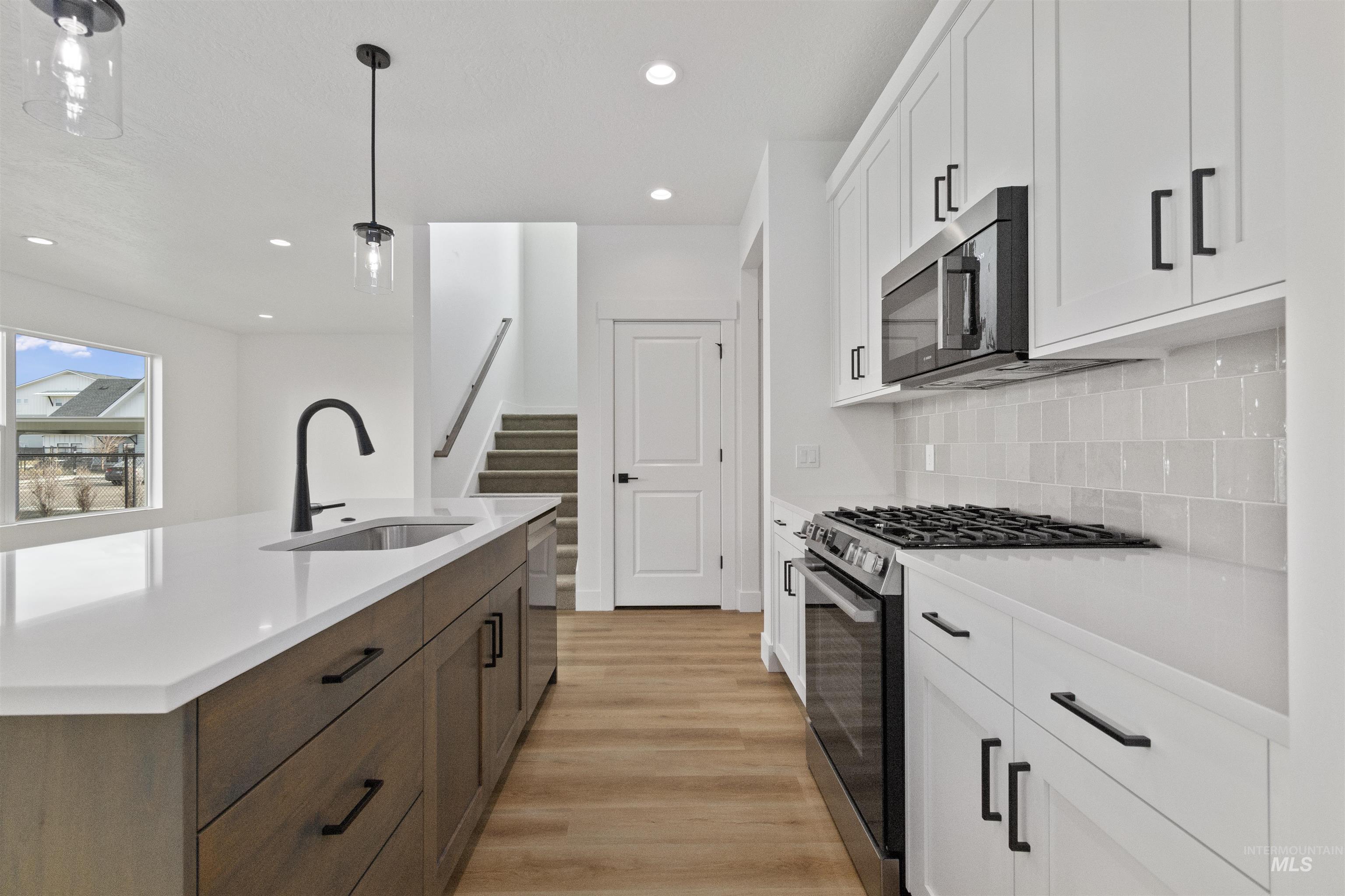 764 South Calhoun Lane Star, ID 83669 - Photo 10 of 48 Kitchen featuring white cabinets, stainless steel appliances, hanging light fixtures, light wood finished floors, and recessed lighting