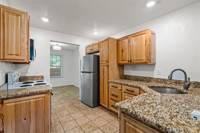a kitchen with granite countertop wooden cabinets and a window