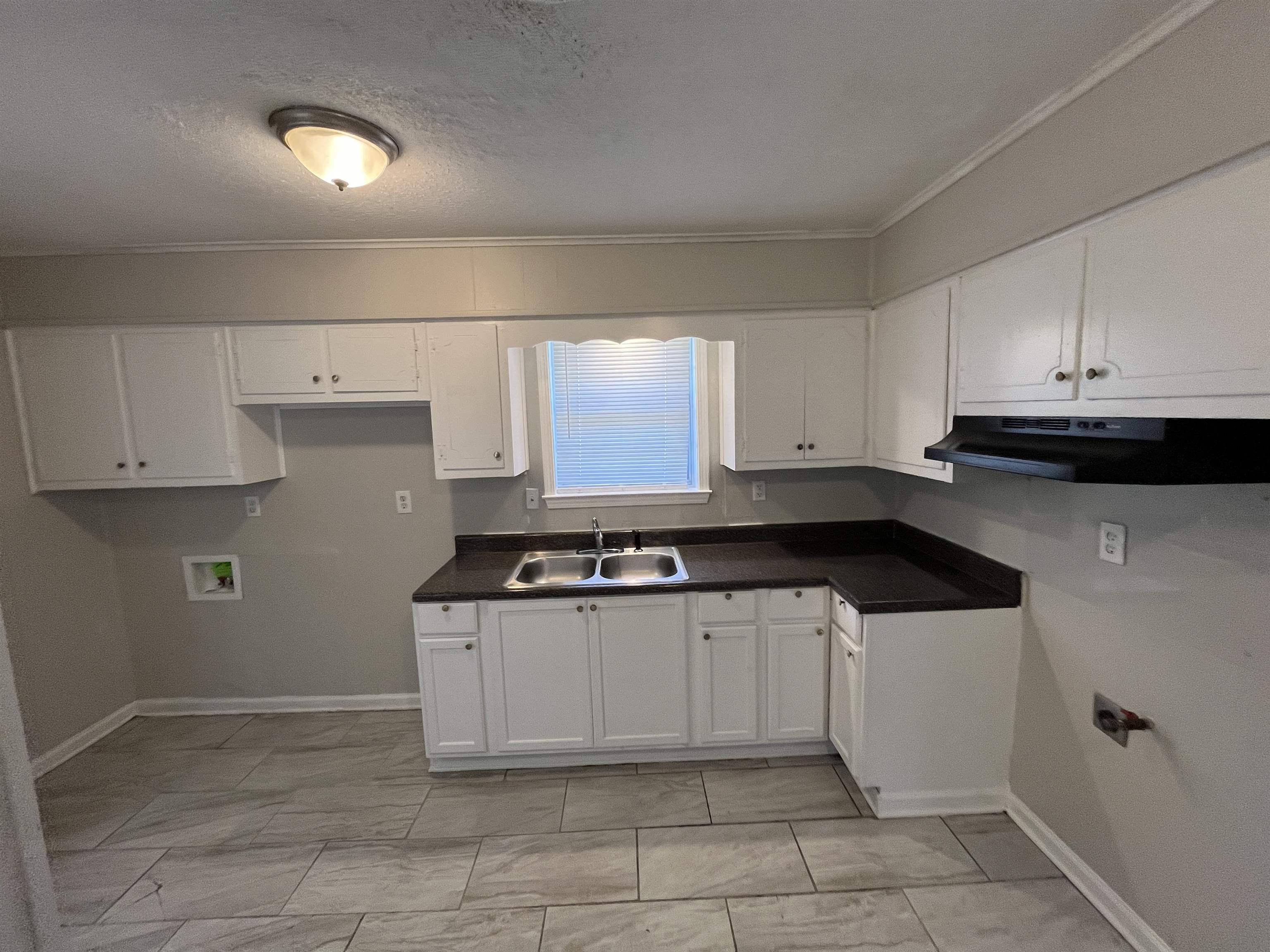 3973 Brompton Road Memphis, TN 38118 - Photo 2 of 17 Kitchen with white cabinetry, a sink, dark countertops, and under cabinet range hood