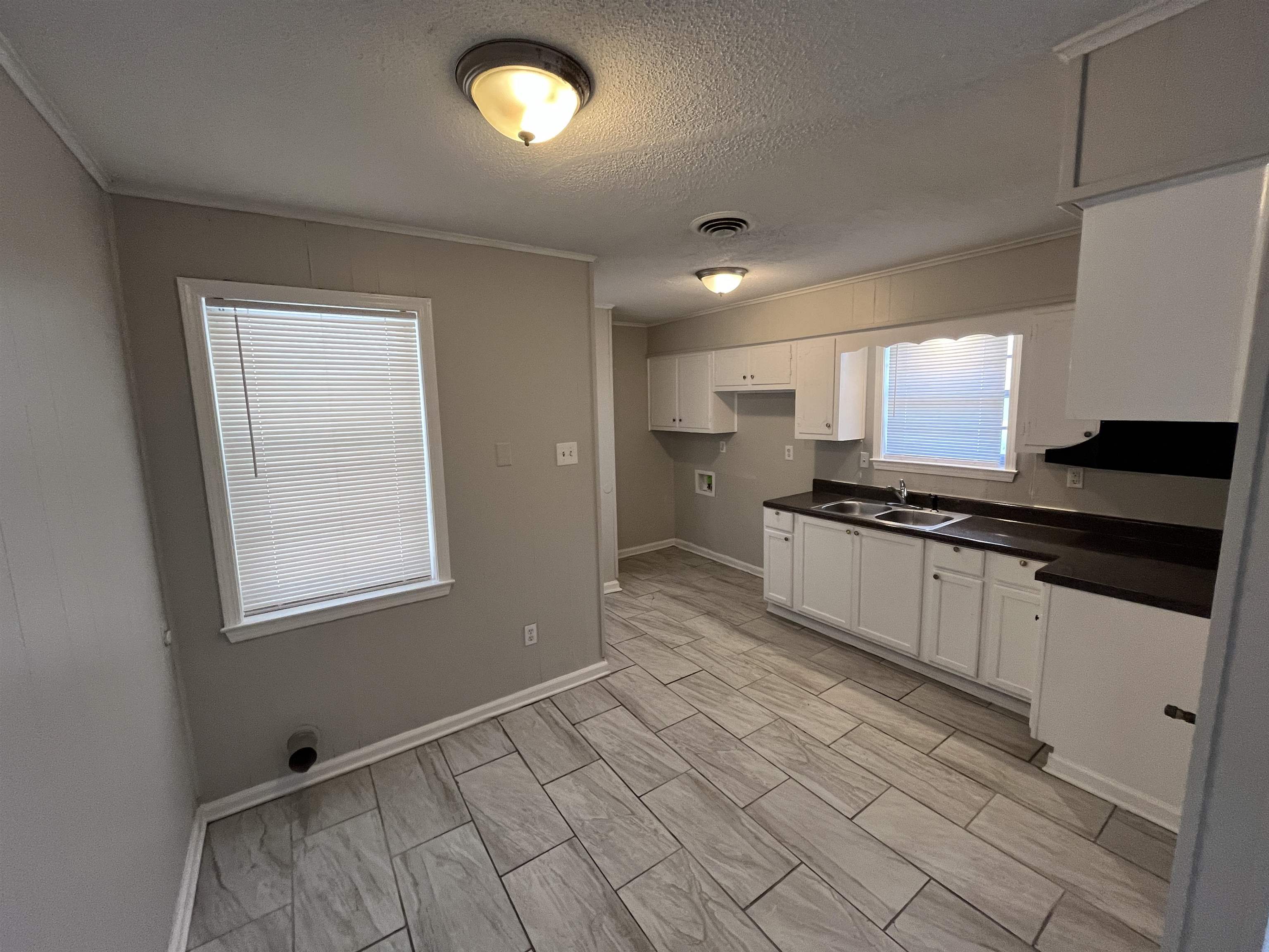 3973 Brompton Road Memphis, TN 38118 - Photo 3 of 17 Kitchen with a sink, white cabinetry, a textured ceiling, visible vents, and dark countertops