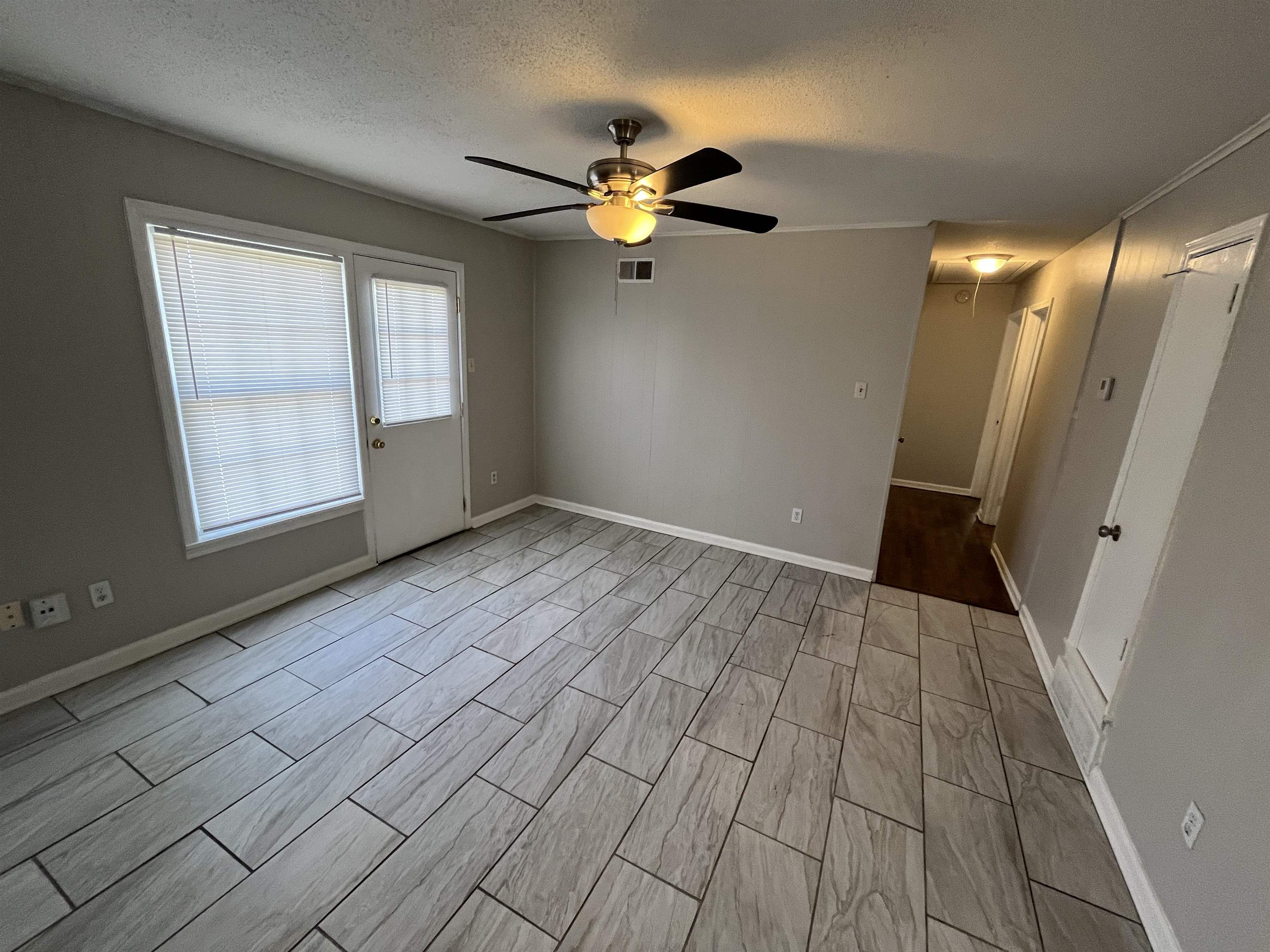 3973 Brompton Road Memphis, TN 38118 - Photo 6 of 17 Unfurnished room featuring a ceiling fan, attic access, a textured ceiling, wood tiled floor, and visible vents