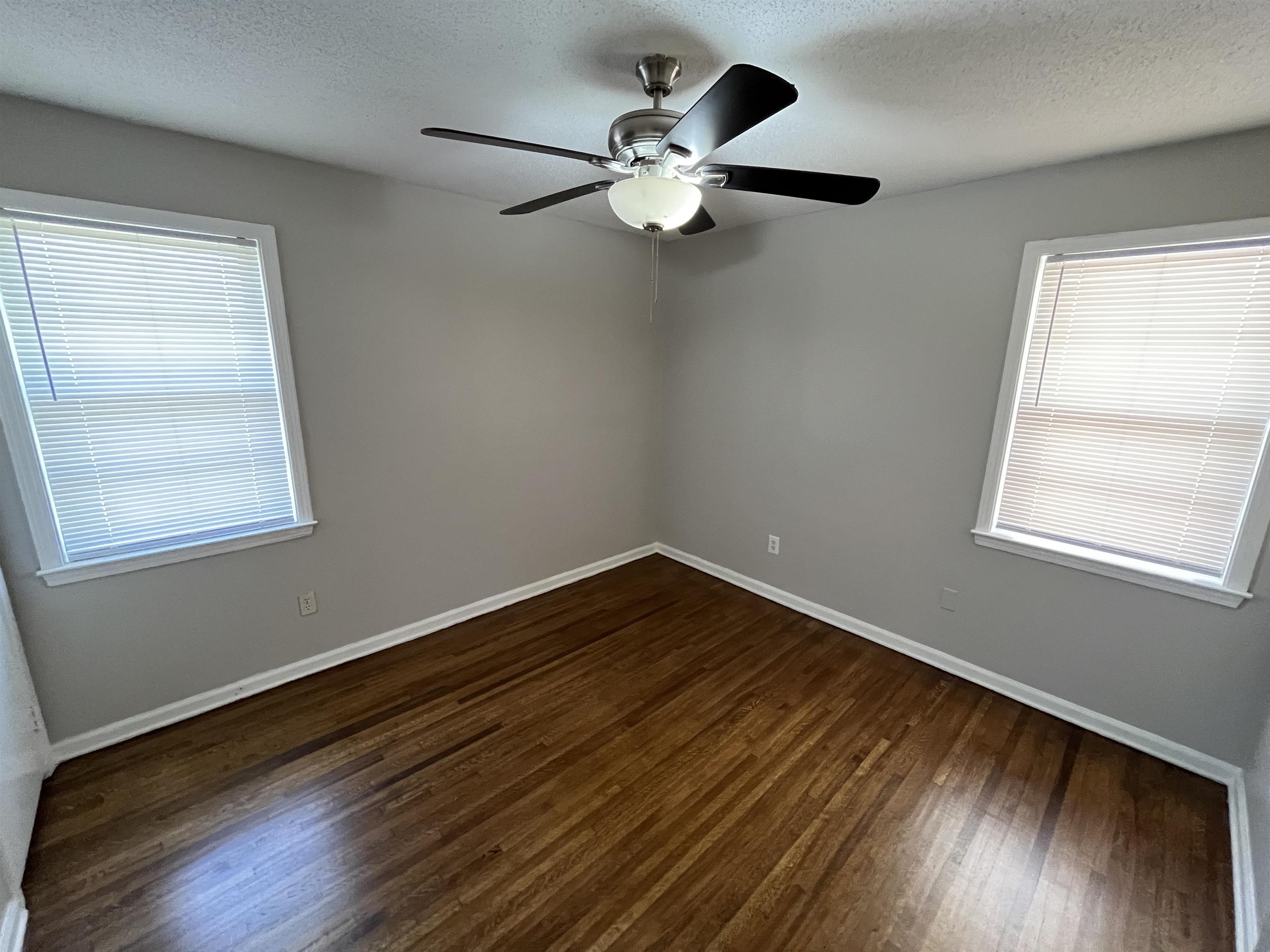 3973 Brompton Road Memphis, TN 38118 - Photo 8 of 17 Spare room featuring baseboards, a ceiling fan, dark wood-type flooring, and a textured ceiling