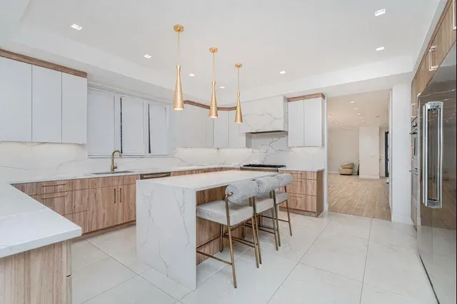 a kitchen with stainless steel appliances granite countertop a sink and a refrigerator