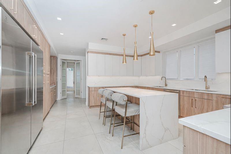 104 Village Road South Brooklyn, NY 11223 - Photo 15 of 36 a kitchen with a table chairs refrigerator and cabinets