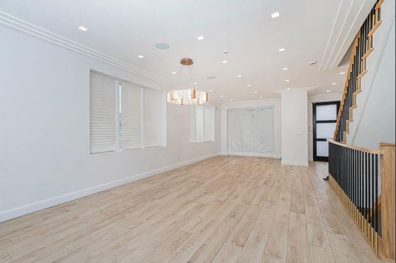 104 Village Road South Brooklyn, NY 11223 - Photo 17 of 36 an empty room with wooden floor and windows