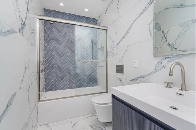 a bathroom with a sink a toilet and shower