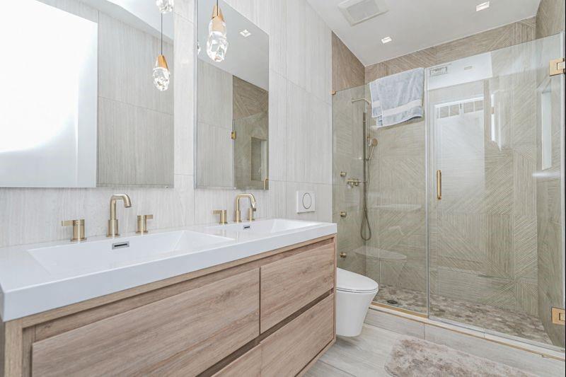 104 Village Road South Brooklyn, NY 11223 - Photo 32 of 36 a bathroom with a double vanity sink toilet mirror and shower