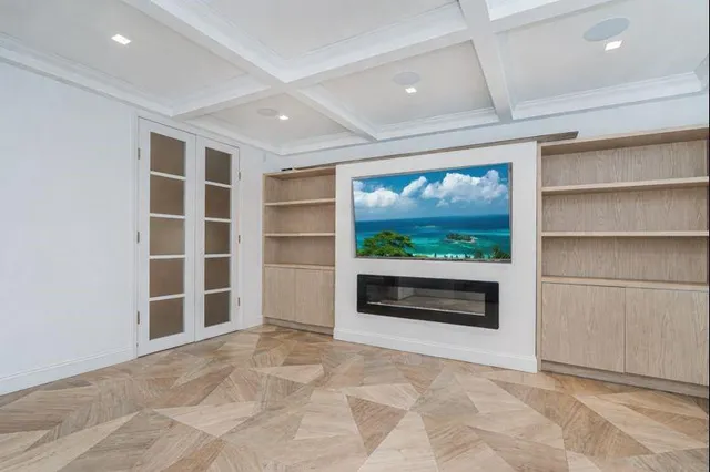 a view of an empty room with a window and kitchen