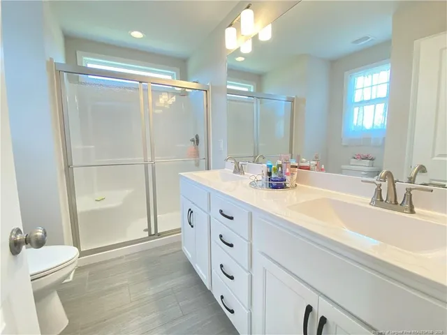 a bathroom with a double vanity sink mirror double and shower