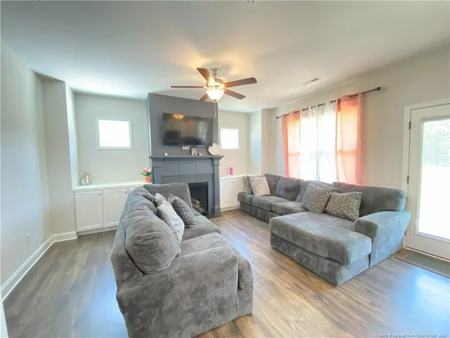 a living room with furniture a flat screen tv and a fireplace