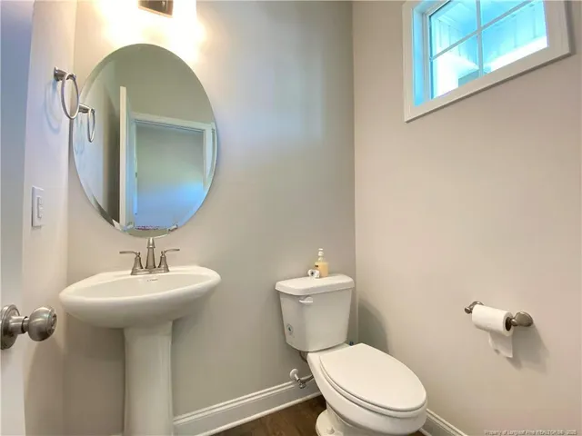 a bathroom with a toilet sink and mirror