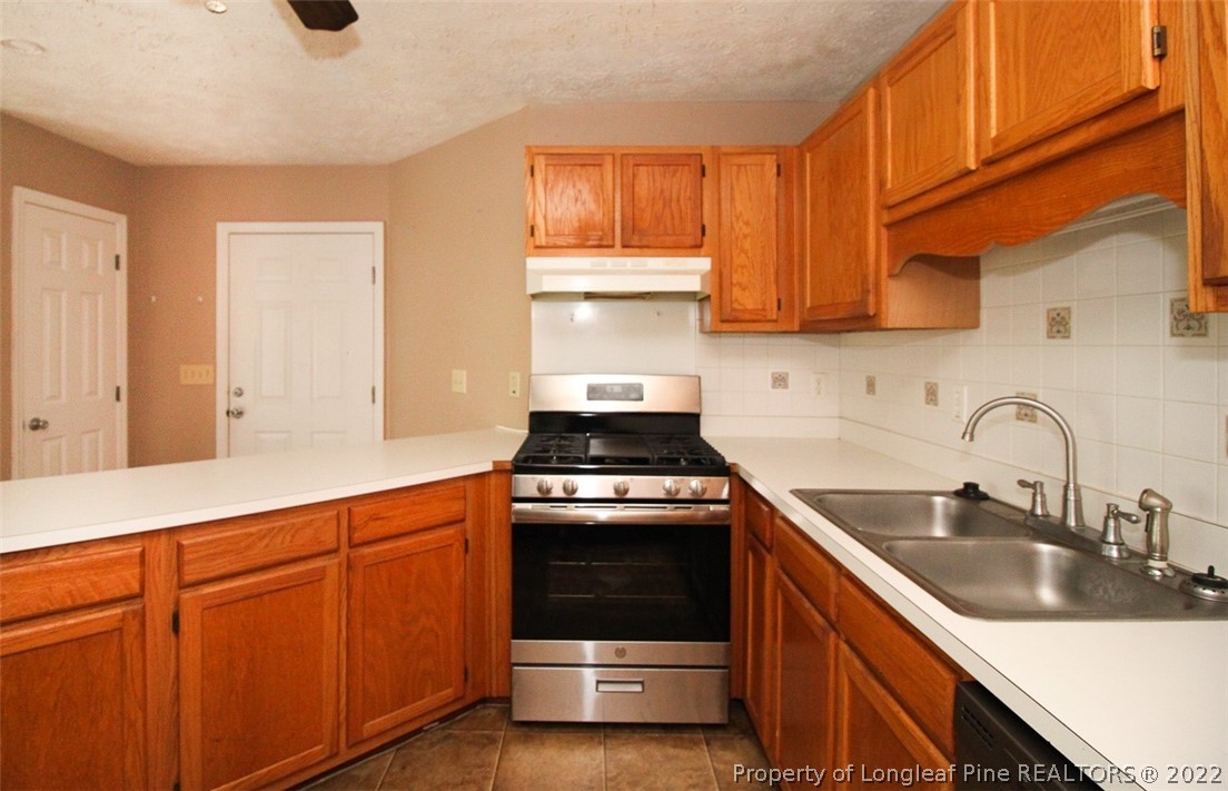 220 Overton Road Raeford, NC 28376 - Photo 8 of 30 a kitchen with granite countertop a sink stainless steel appliances wooden cabinets and a window