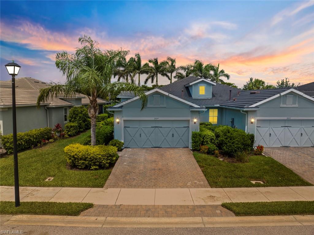 a front view of a house with a yard and potted plants