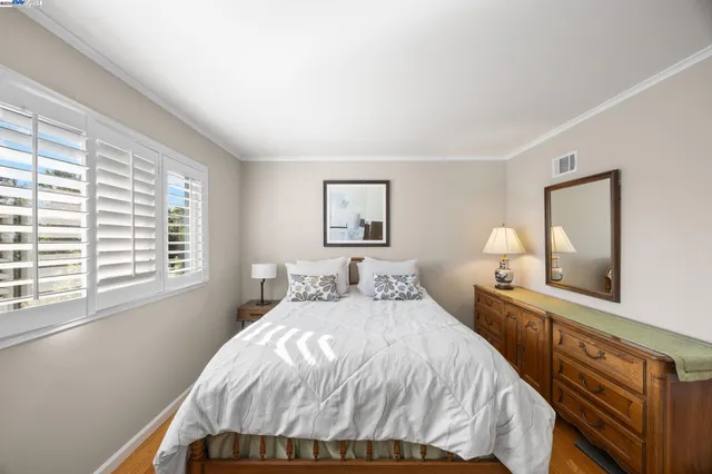 a bedroom with a bed and a painting on the wall