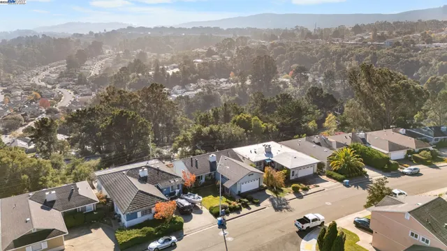 an aerial view of residential houses with outdoor space and parking