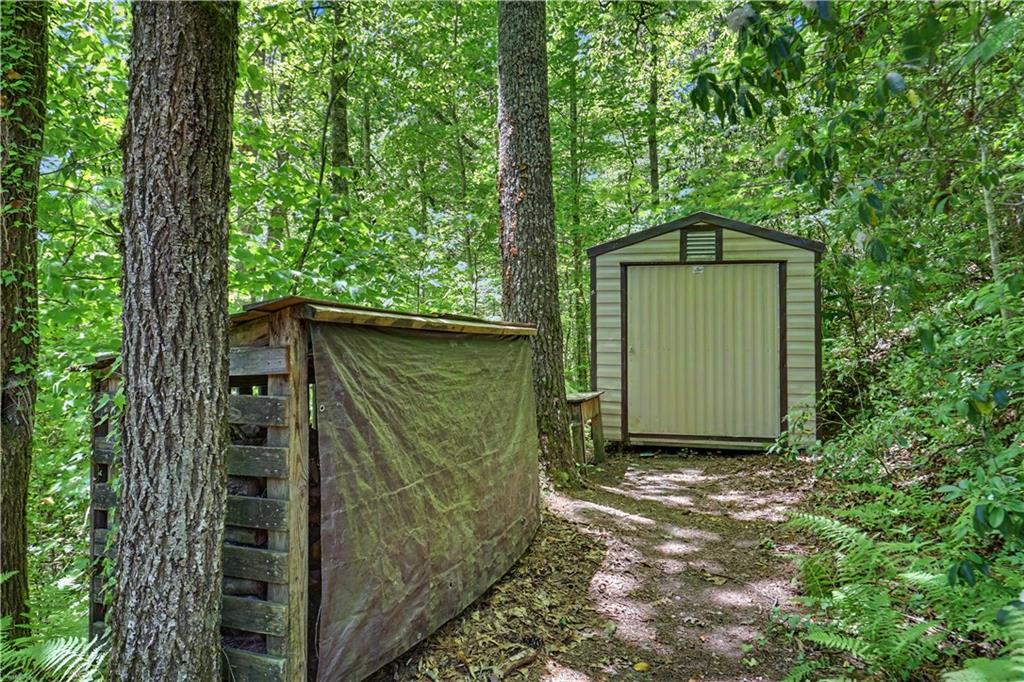 102 Moses Road Rabun Gap, GA 30568 - Photo 34 of 40 a pathway of a house with a small yard and wooden fence