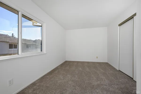 a view of empty room with window and ceiling fan