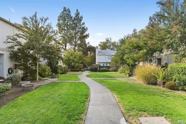 a view of a hallway with wooden floor and closet